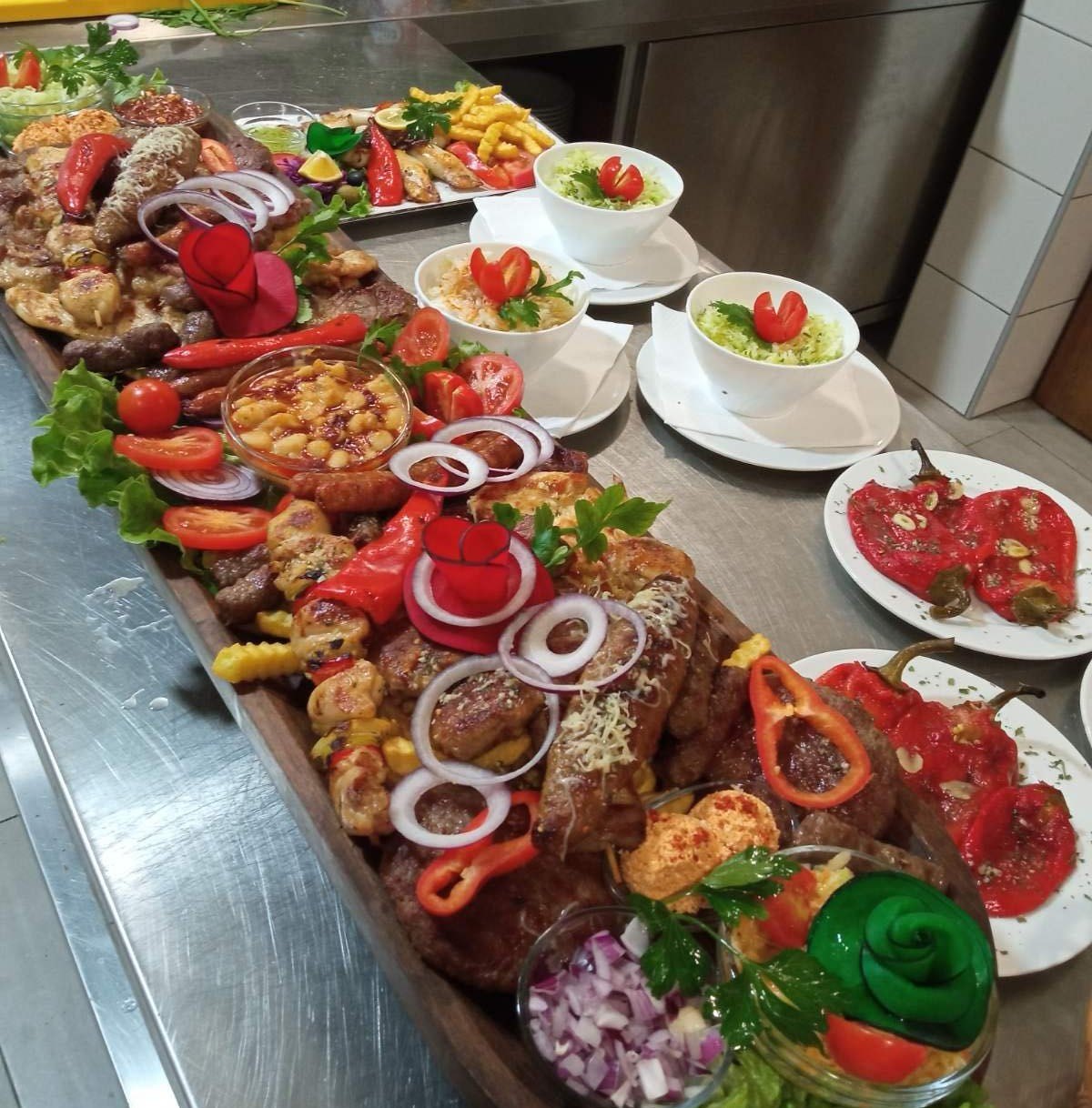 Duga daska sa miješanim mesom, prilozima i salatama za cijeli sto